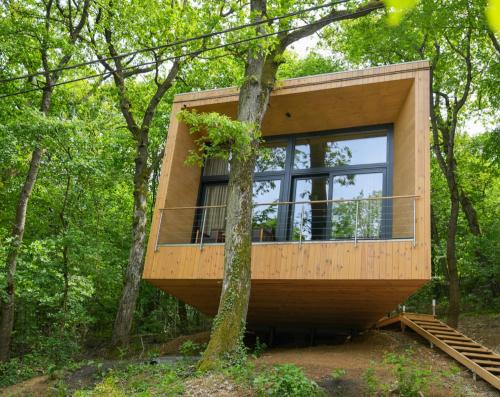 a tree house in the woods with a large window at Villa Marrakesh Noszvaj in Noszvaj