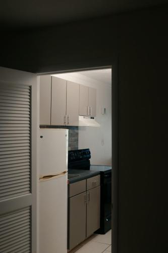 a kitchen with white cabinets and a white refrigerator at Southern Breeze Ocean Front Hotel in Myrtle Beach