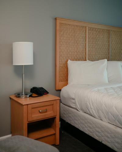 a bedroom with a bed and a lamp on a table at Southern Breeze Ocean Front Hotel in Myrtle Beach