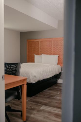 a bedroom with a bed and a wooden headboard at Southern Breeze Ocean Front Hotel in Myrtle Beach