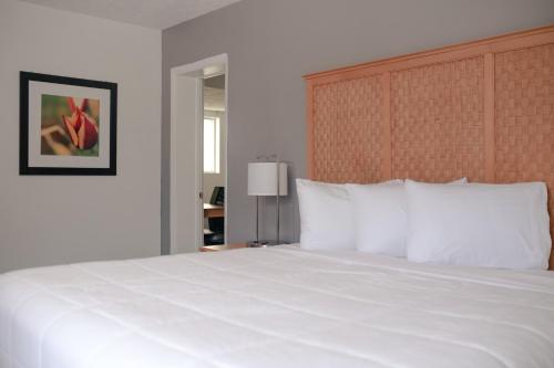 a bedroom with a large white bed with white pillows at Southern Breeze Ocean Front Hotel in Myrtle Beach