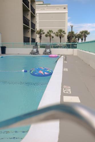 a swimming pool with a pool noodle in the water at Southern Breeze Ocean Front Hotel in Myrtle Beach