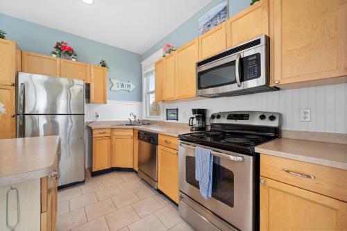 a kitchen with stainless steel appliances and wooden cabinets at The Cottontail - 6 Meadowview Lane in Cherry Valley