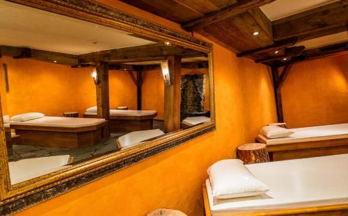 a room with two beds and a large mirror at Hotel Bellerive in Zermatt