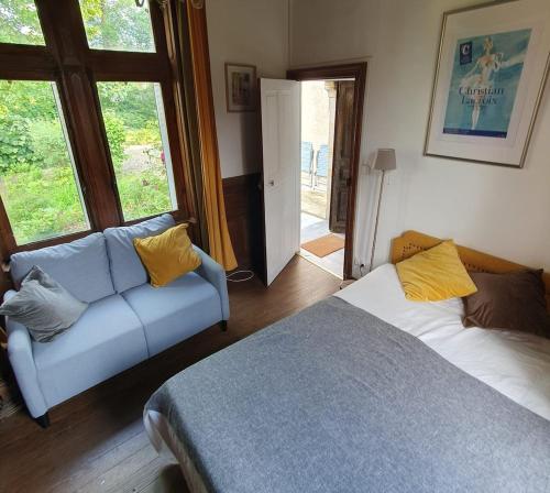 une chambre avec un lit, un canapé et une fenêtre dans l'établissement Maison la Paroisse, proche des Thermes, à Bourbon-lʼArchambault