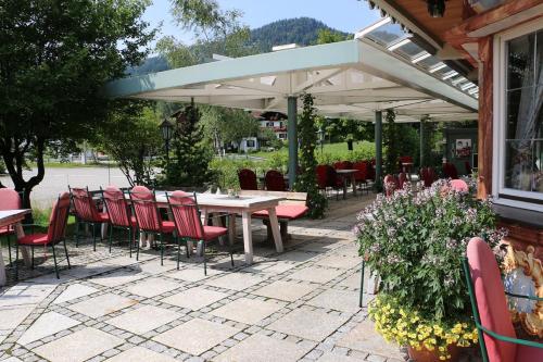 un patio con mesa y sillas bajo una sombrilla en DEVA Villa Mittermaier, en Reit im Winkl