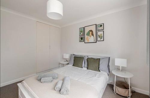 a white bedroom with a bed and two lamps at Modern Coastal Retreat HotTub FirePit SkyTV in Lymington