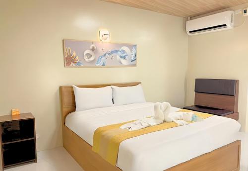 マニラにあるAlgers Suitesのベッド2台とテレビがあるホテルの部屋