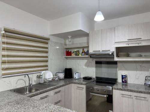 a kitchen with a sink and a stove top oven at Casa de ensueño, con vista al Mar in Manta