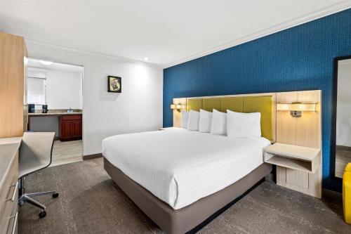 a bedroom with a large bed and a blue wall at SureStay Hotel by Best Western Santa Monica in Los Angeles