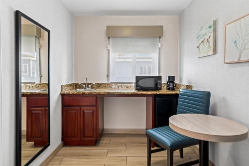 a room with a table and a sink and a table and chairs at SureStay Hotel by Best Western Santa Monica in Los Angeles