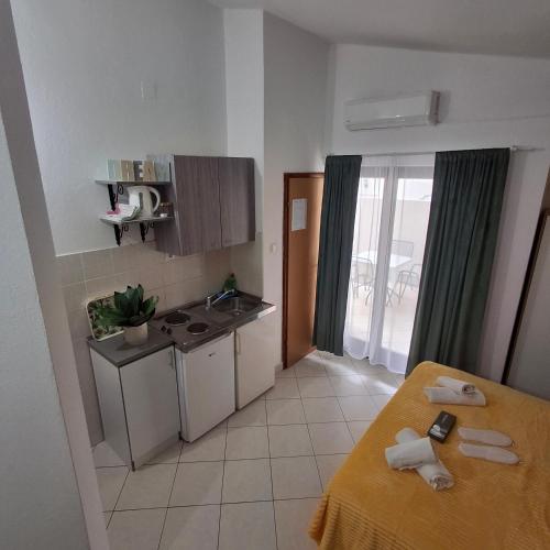a small kitchen with a sink and a table in a room at Apartmani Villa Anita in Neum