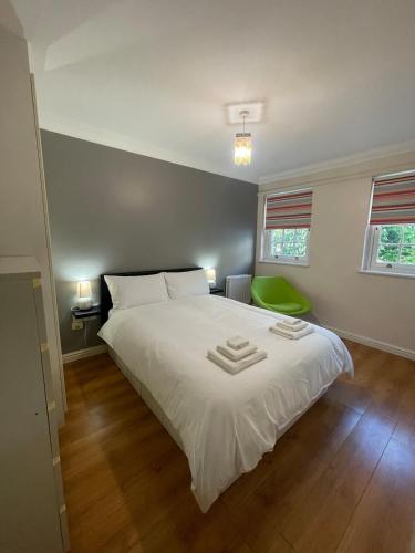 a bedroom with a white bed with two towels on it at Gatwick 1 Bedroom Apartment in Chipstead