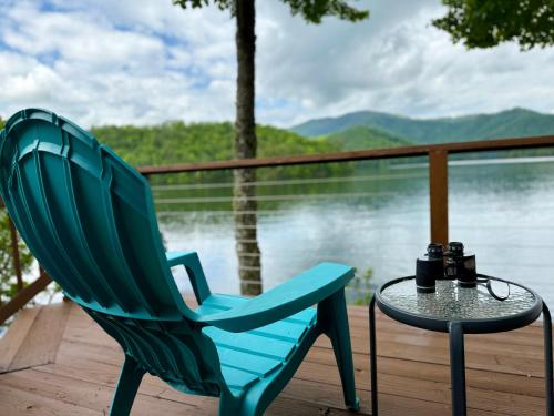 a blue chair and a table on a deck with a view of the water at Lakefront A-Frame on a Point, Pet-Friendly in Robbinsville