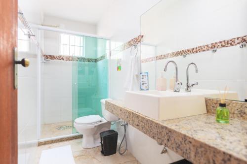 a bathroom with a sink and a toilet and a shower at Piratas de Geriba Guest Rooms in Búzios