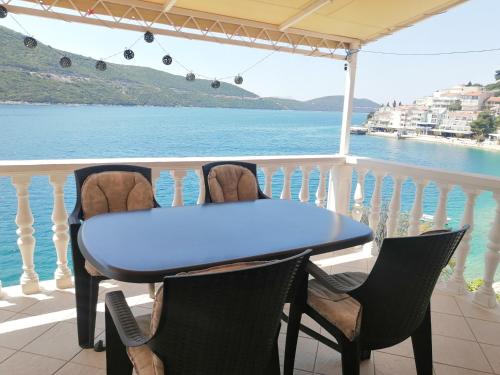 a table and chairs on a balcony with a view of the water at Apartmani Villa Anita in Neum