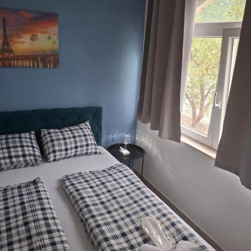 a bedroom with two beds and a window at Apartmani Villa Anita in Neum