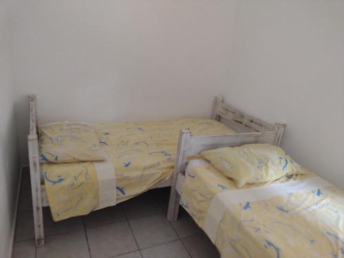 two twin beds in a small room with at Casa de praia sertãozinho in São Sebastião