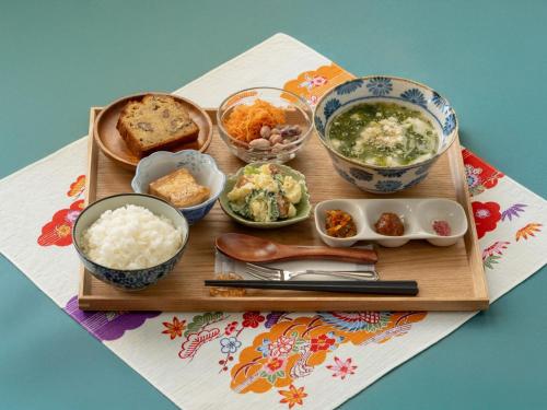 a wooden tray with various dishes of food on a table at Ada Garden Hotel Okinawa in Kunigami