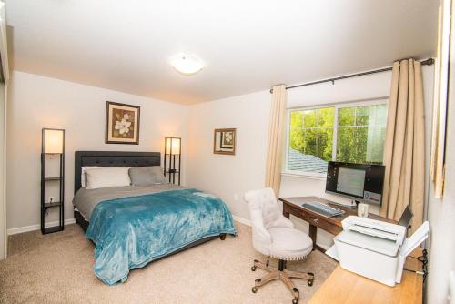 a bedroom with a bed and a desk with a computer at Serene Four Bedroom Lakefront Home in Wasilla