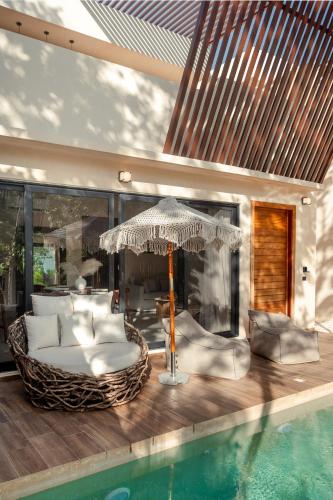 a living room with an umbrella next to a pool at Bali 4BR Villa w Pool, Rooftop Jacuzzi and BBQ in Tulum