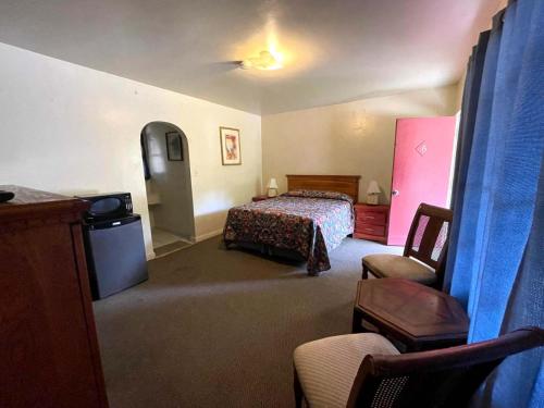 サンタクラリタにあるSierra Pelona Motelのベッドと椅子のあるホテルの部屋