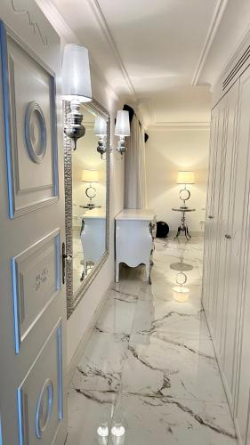 La salle de bains est pourvue d'une coiffeuse, d'un miroir et d'une porte. dans l'établissement Luxury Sea View Penthouse, Monaco Border, 150m2, Parking, à Beausoleil