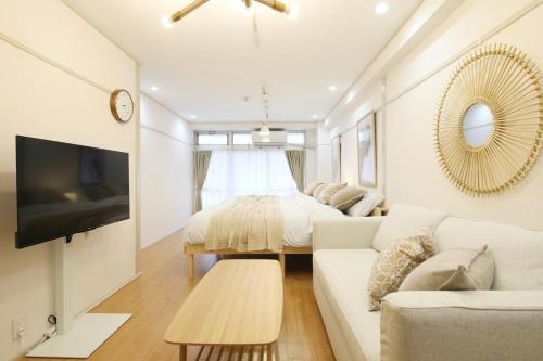 a white living room with a couch and a bed at オグラビル 203 in Tokyo