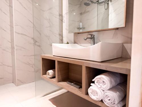 アンヘレスにあるGoodnews Innの洗面台、鏡、タオルを備えたバスルーム