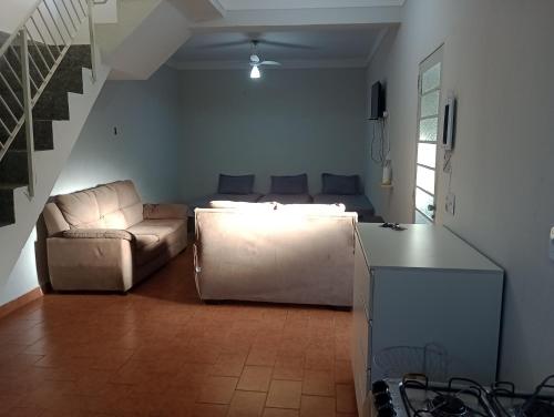 a living room with a couch and a living room at Espaço Gardenias II in Guaratinguetá