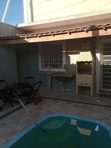 a patio with a grill and a table and a swimming pool at Espaço Gardenias II in Guaratinguetá