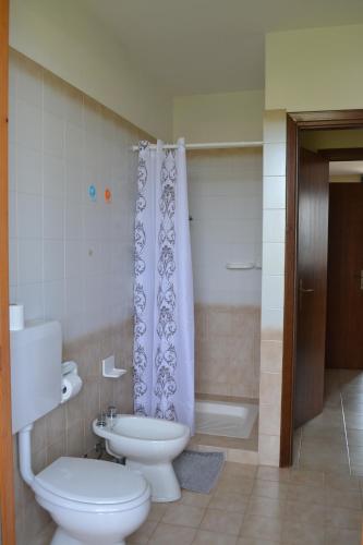 a bathroom with a toilet and a shower curtain at Residenza Benini in Bardolino