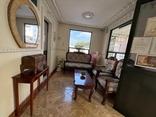a living room with chairs and a table and a mirror at Hotel Arbis in Puebla