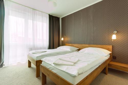 two twin beds in a room with a window at Hotel Lineas in Prešov