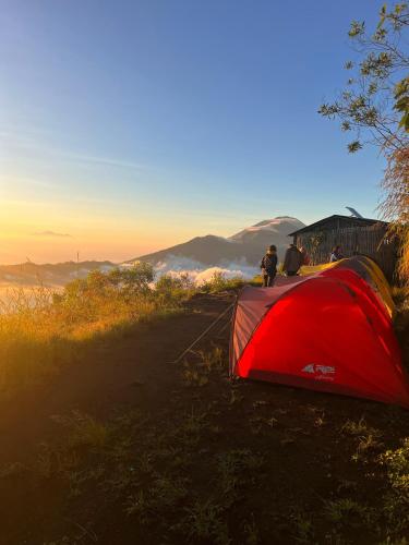 a red tent sitting on the side of a hill at Batur Sunrise Camp in Kintamani