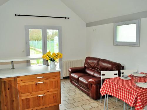 une cuisine avec un canapé et une table avec une nappe dans l'établissement Charmant gîte au cœur du Val de Loire avec jardin privatif, proche des châteaux et vignobles - FR-1-381-50, à Limeray