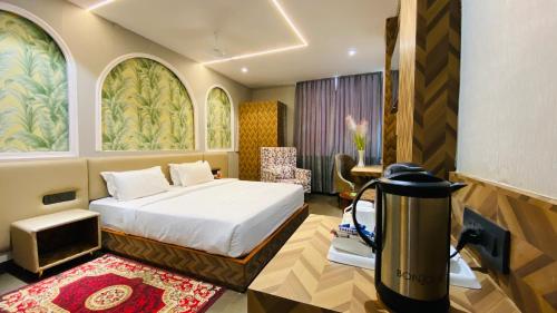 a bedroom with a bed and a desk with a television at The Byke Grassfield Resort with Outdoor Pool, Shyam Nagar, Jaipur in Jaipur