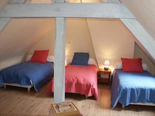 a attic room with two beds with blue and red pillows at Gîte familial spacieux avec jardin privé, proche châteaux et zoo, jeux pour enfants, billard et cheminée - FR-1-381-6 in Bléré