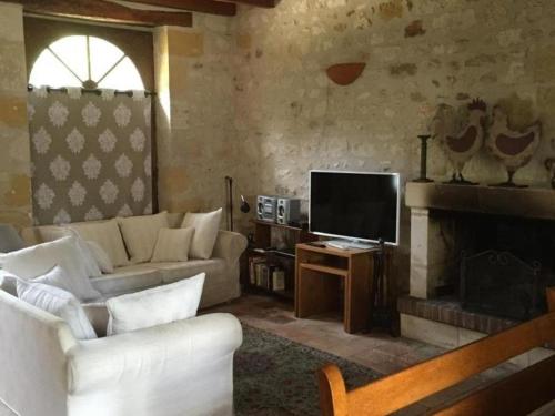 un salon avec un canapé et une télévision dans l'établissement Gîte enchanteur 4 km de Chinon avec jardin privé, cheminée, salle de jeux et équipements bébé inclus - FR-1-381-188, à Saint-Benoît-la-Forêt