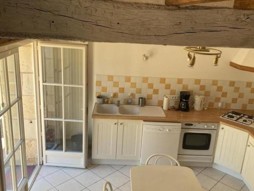 une petite cuisine avec un évier et une cuisinière dans l'établissement Gîte rural 3 niveaux avec jardin privé, à proximité des châteaux de la Loire - FR-1-381-169, à Saint-Épain