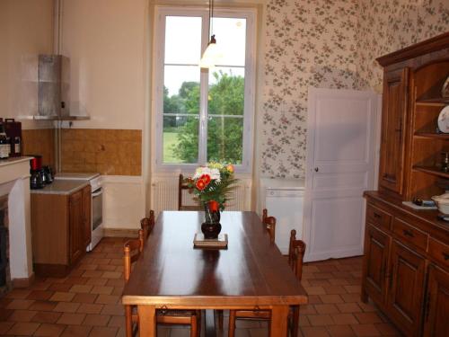 une cuisine avec une table avec un vase de fleurs dessus dans l'établissement Maison XIXe, grand jardin clos, au cœur des vignobles, près de Chinon et de la Loire à Vélo - FR-1-381-445, à Beaumont-en-Véron