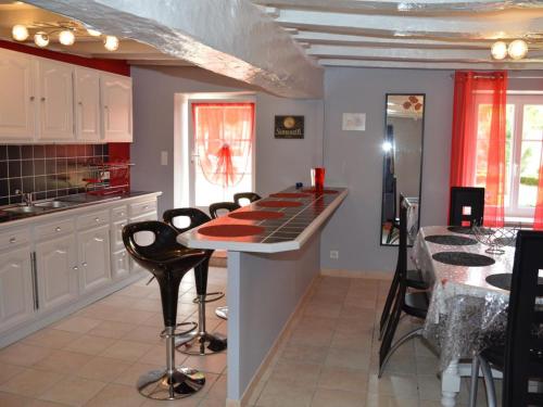 - une cuisine avec un bar doté de chaises noires et d'une table dans l'établissement Maison rénovée au cœur des vignobles avec jardin, modernité et confort près des châteaux de la Loire - FR-1-381-168, à Bourgueil