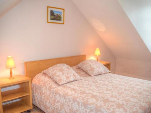 a bedroom with a bed and two lamps on tables at Gîte lumineux à Montrésor avec jardin privatif et équipements complets, proche du Zooparc de Beauval - FR-1-381-72 in Montrésor
