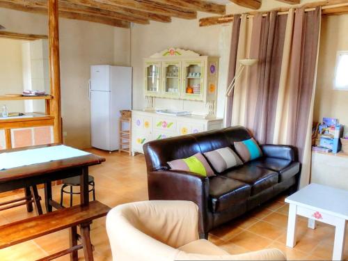 un salon avec un canapé en cuir et une table dans l'établissement Location saisonnière: Gîte de charme avec jardin privé, proche des châteaux de la Loire et de la nature - FR-1-381-200, à Mazières-de-Touraine