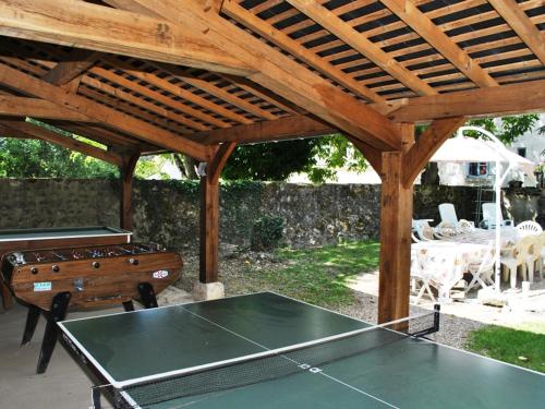 une table de ping-pong sous une pergola en bois avec une table de ping-pong dans l'établissement Gîte rural rénové 3 niveaux, jardin privatif, équipements loisirs, draps inclus, cheminée, WiFi - FR-1-381-475, à Bléré