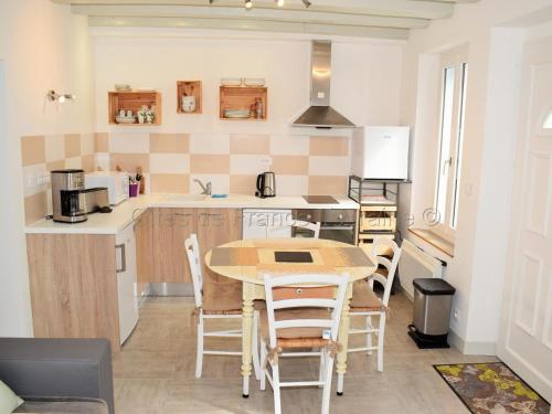 une cuisine avec une table et des chaises dans une pièce dans l'établissement Charmante maison avec terrasse près des châteaux de la Loire, idéale pour familles et animaux acceptés - FR-1-381-154, à Limeray