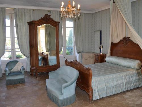 une chambre avec un lit, une chaise et un miroir dans l'établissement Château Authentique avec Piscine Privée, Proche Châteaux de la Loire et Zoo de Beauval - FR-1-381-485, à Châtillon-sur-Indre