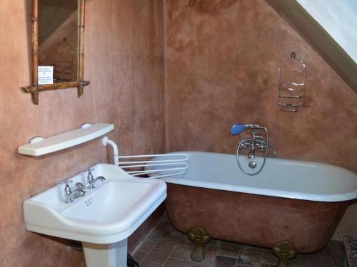 une salle de bain avec une baignoire et un lavabo dans l'établissement Château Authentique avec Piscine Privée, Proche Châteaux de la Loire et Zoo de Beauval - FR-1-381-485, à Châtillon-sur-Indre