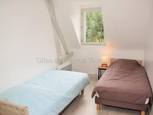 une chambre avec deux lits et une fenêtre dans l'établissement Charmante maison avec terrasse près des châteaux de la Loire, idéale pour familles et animaux acceptés - FR-1-381-154, à Limeray