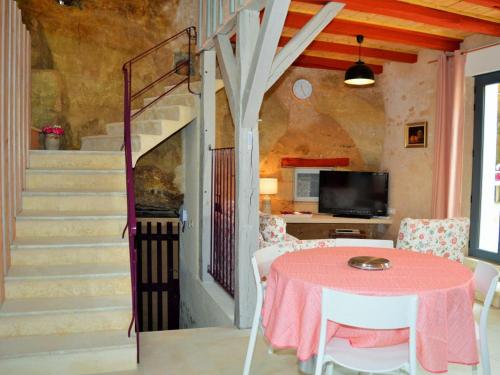 une salle à manger avec une table et un escalier dans l'établissement Gîte atypique troglodytique, calme, proche de la Loire, tout inclus, avec cour privative et garage - FR-1-381-280, à Savonnières